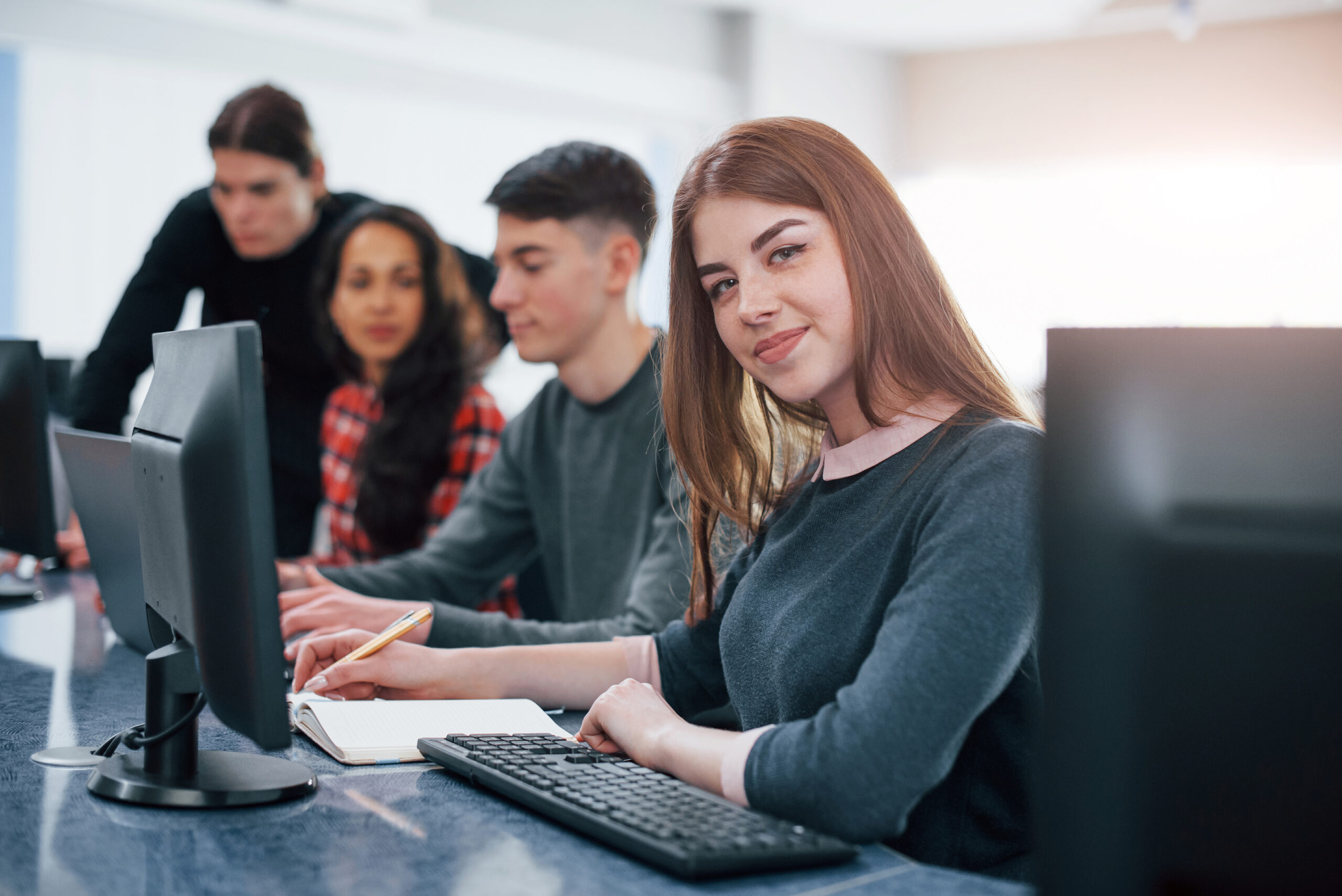 Pretty girl. Group of young people in casual clothes working in the modern office.